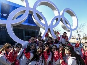Pyeongchang Olympic volunteers pose for a photo next next to the Olympics rings ahead of the Pyeongchang 2018 Winter Olympic Games in Pyeongchang on Feb. 6, 2018 (Dimitar DILKOFF / AFP)