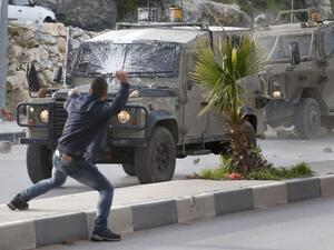 Palestinians throw stones at Israeli army vehicles after forces entered the village of Halhoul in the occupied West Bank on Feb. 07, 2018. A Palestinian stabbed a security guard at the entrance to an Israeli settlement and was shot dead in the latest violence in the occupied West Bank, Israel's military said.
(HAZEM BADER / AFP)