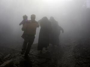 A Syrian family walks through a dust cloud while fleeing from reported regime air strikes in the rebel-held town of Jisreen, in the besieged Eastern Ghouta region on the outskirts of the capital Damascus, on Feb. 8, 2018. A fourth consecutive day of heavy regime bombing raids on the rebel-held enclave of Eastern Ghouta near Damascus killed 22 civilians on Feb. 8, a monitor said.
(ABDULMONAM EASSA / AFP)