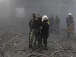 A wounded man is helped out of the destruction following air strikes in the rebel-held enclave of Arbin in the Eastern Ghouta near Damascus on Feb. 8, 2018 (ABDULMONAM EASSA / AFP)