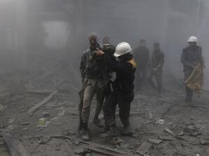 A wounded man is helped out of the destruction following air strikes in the rebel-held enclave of Arbin in the Eastern Ghouta near Damascus on Feb. 8, 2018 (ABDULMONAM EASSA / AFP)