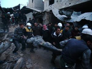 Members of Syrian civil defense forces known as the White Helmets evacuate a victim of an air strike in the rebel-held enclave of Arbin in the Eastern Ghouta near the capital Damascus on Feb. 9, 2018 (ABDULMONAM EASSA / AFP)