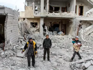 Syrian civil defense volunteers stand amid debris and destruction following a reported regime airstrike in the besieged town of Douma in the Eastern Ghouta region, on the outskirts of the capital Damascus, on Feb.15, 2018. 
(Hamza Al-Ajweh / AFP)