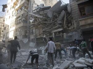 Syrian civilians and rescuers gather at the site of an air strike. (AFP)
