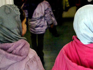 Investigation into online abuse targeting the head teacher of an East London where girls younger than the age of eight were banned from wearing the hijab (AFP)