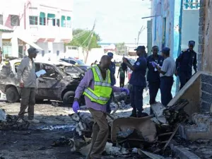 Somali soldiers and investigators work at the site of an explosion outside a restaurant in Mogadishu on April 9, 2016 (AFP)