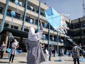 Palestinian schoolgirls fly kites outside their classrooms at a school belonging to the United Nations Relief and Works Agency for Palestinian Refugees (AFP/File Photo)