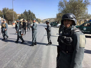 Policemen gather outside the building where the attack occurred (AFP)