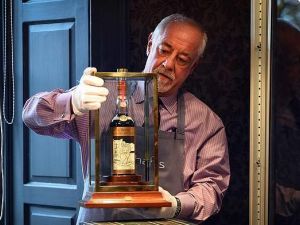 A Bonhams porter shows the bottle of Macallan Valerio Adamai 1926 whisky to packed auction house in Edinburgh today. The whisky was bottled in 1986 having been stored in a vat for 60 years previously (AFP)