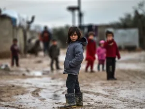 Children stand in a muddy street at a refugee camp on Jan. 26, 2018 at the Syrian town of Azaz (AFP)