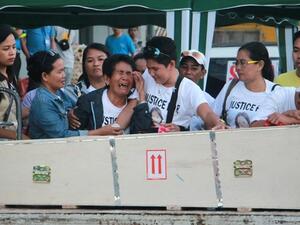 Eva (3rd L), the mother of Filipina worker Joanna Demafelis whose body was found inside a freezer in Kuwait, cries in front of the wooden casket containing her daughter's body shortly after its arrival from Manila at Iloilo International Airport in Iloilo province, central Philippines, on Feb. 17, 2018. (AFP)