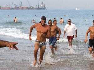 Triathlon participants emerge from the water after swimming 1,500 meters. (The Daily Star)
