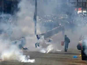 Palestinian men run for cover from tear gas thrown by Israeli forces (AFP/File Photo)