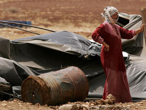 A Palestinian bedouin woman stands outside her demolished home. (AFP/File)