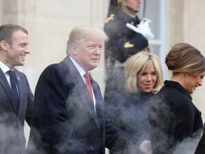 Smoke billows from the exhaust of the US president's official state car, also known as 'The Beast', as French President Emmanuel Macron (L) and his wife Brigitte Macron (R) bid farewell to U.S. President Donald Trump and First Lady Melania Trump at the Elysee Palace in Paris on November 10, 2018 Ludovic MARIN / AFP