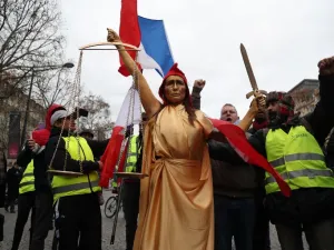 A woman, wearing a Phrygian cap to symbolically represent Justice, and yellow vest protestors 
Zakaria ABDELKAFI / AFP