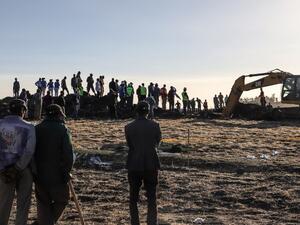 People watch workers at the crash site of a Nairobi-bound Ethiopian Airlines flight near Bishoftu (AFP)