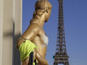People stand next to a statue wearing a "Yellow vest" as protesters gather to take part in a 20th consecutive saturday of demonstrations called by the "yellow vests" (gilets jaunes) movement on March 30, 2019, in Paris. 
Geoffroy VAN DER HASSELT / AFP 
