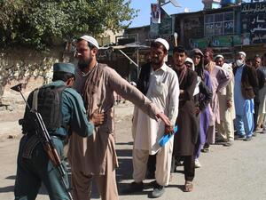 An Afghan policeman searches voters before casting their votes at a polling centre for the country's legislative election in Khost Province on October 20, 2018. (AFP/File)