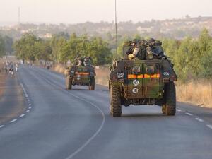 French army soldiers stand on armoured vehicles as they leave Bamako. (AFP PHOTO /ERIC FEFERBERG)