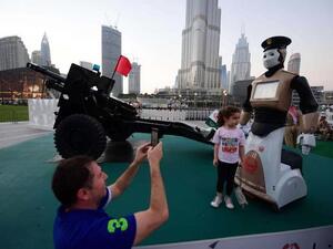 Ahead of the game. A 2017 file picture shows people taking a picture with the world’s first operational police robot near the Burj Khalifa in Dubai. (AFP)