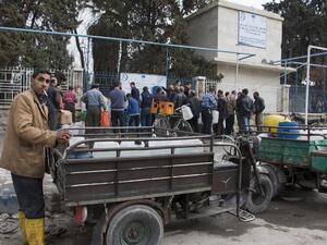 Aleppo residents line up outside to refill water cans as the ceasefire encourages people to be out in public. (AFP/Karam Al-Masri)
