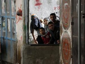 Palestinians on the look out as young people and Israeli soldiers clash (AFP/File Photo)