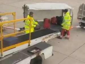 A Manchester airport baggage handler's rough treatment of passengers' luggage has been captured on video. (Screenshot)