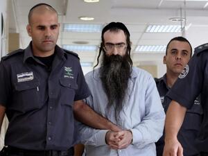 Ultra-Orthodox Jew Yishai Shlissel, who was convicted of killing a 16-year-old Israeli girl during the Jerusalem Gay Pride parade last year, is escorted into court by police on June 26, 2016 in Jerusalem. (AFP/Gail Tibbon)