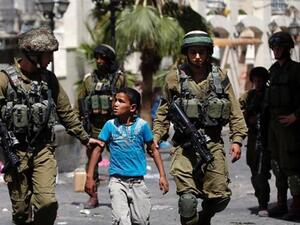 Israeli soldiers arrest a young Palestinian boy following clashes in the West Bank. (AFP/File) 