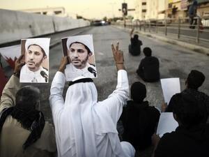 Bahrainis hold up portraits of the head of the banned Shia opposition movement al-Wefaq, Sheikh Ali Salman during clashes with riot police following a protest against his arrest on December 29, 2014 in Bilad al-Qadeem, a suburb of Manama. (AFP / Mohammed al-Shaikh)