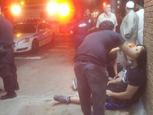 Passers-by attend to Muslim teen violently beaten outside mosque. (Twitter) 