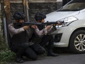 Mobile brigade police take position as they patrol outside the Surabaya police headquarters following a suicide attack in Surabaya on May 14, 2018. (JUNI KRISWANTO / AFP)