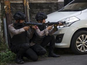 Mobile brigade police take position as they patrol outside the Surabaya police headquarters following a suicide attack in Surabaya on May 14, 2018. (JUNI KRISWANTO / AFP)