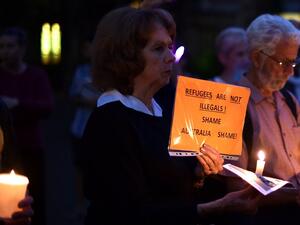 This picture taken on April 30, 2016 shows participants holding placard and candles during a vigil in Sydney for an Iranian refugee who died after setting himself on fire on the Pacific island of Nauru. (AFP/Saeed Khan)