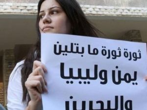 متظاهرة تحمل لافتة امام السفارة البحرينية في لبنان