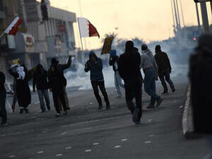 Bahraini protesters run for cover from tear gas during clashes with police in the village of Sitra, south of the capital Manama, on January 29, 2016. (AFP)