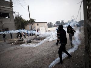 Bahraini protesters take cover from tear gas during clashes with police following a demonstration on February 13, 2015, to mark the fourth anniversary of the Arab Spring-inspired uprisings in 2011. (AFP/File)