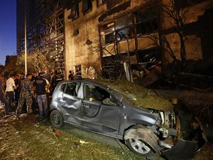 Security officials and civilians survey the aftermath of an explosion outside of Blom Bank in Beirut on the night of June 12, 2016. (AFP/Anwar Amro)