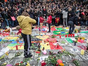 People gather to observe a minute of silence in memory of the victims of the Brussels airport and metro bombings, on the Place de la Bourse in central Brussels, on March 23, 2016, a day after the triple blasts killed some 30 people and left around 250 injured. (AFP/Aurore Belot)