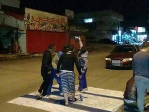 A group of youths take a selfie while standing on an Israeli flag in the northern Jordanian city of Irbid. (Twitter)
