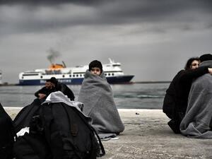 A Syrian child wrapped in a blanket waits on the shore of Lesbos, Greece. (AFP/Aris Messinis)
