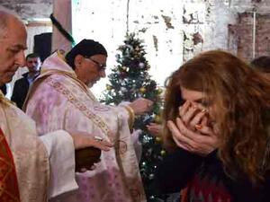 An Iraqi receives the Eucharist during a Christmas mass at the Saint Paul’s church on December 24, 2017 in the country’s second city Mosul. (Ahmad MUWAFAQ / AFP)