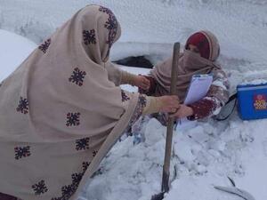 Two female polio vaccinators  trudge through waist high snow, somewhere in Pakistan (Twitter)