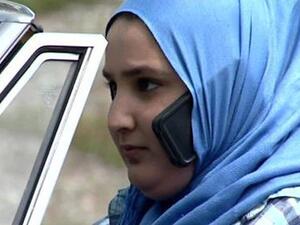 A women uses her phone while driving "hands-free" in her hijab. (Twitter)
