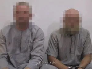 Speaking Russian and wearing matching grey outfits, the two men appear to have been beaten or injured with one showing a cut eye and bruises, in an Amaq video.