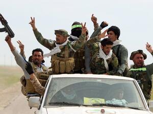 Iraqi Shia fighters from the Popular Mobilization units sit in the back of a vehicle as they drive down a road, in the desert of Samarra, on March 3, 2016, during an operation aimed at retaking areas from Daesh. (AFP/Ahmad al-Rubaye)