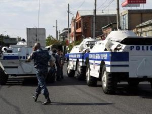 أفراد من الشرطة الأرمينية يغلقون طريقا بعد سيطرة مسلحين على مركز للشرطة واحتجازهم عددا من الرهائن في يريفان

