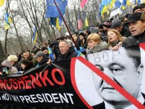 محتجون يحملون لافتة عليها صورة الرئيس الاوكراني بترو بوروشنكو وقد كتب عليها "بوروشنكو ليس رئيسي" في احتجاج نظم دعما للرئيس الجورجي السابق ميخائيل ساكاشفيلي في كييف

