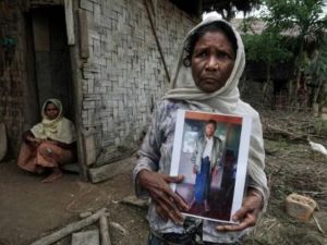 مسلمة من الروهينغا تحمل صورة ابنها الذي طُعن واختطف من منزله في 4 تموز/يوليو 2017 في قرية مونغ هناما في ولاية راخين حيث يقول المسلمون أنهم يعيشون في خوف دائم

